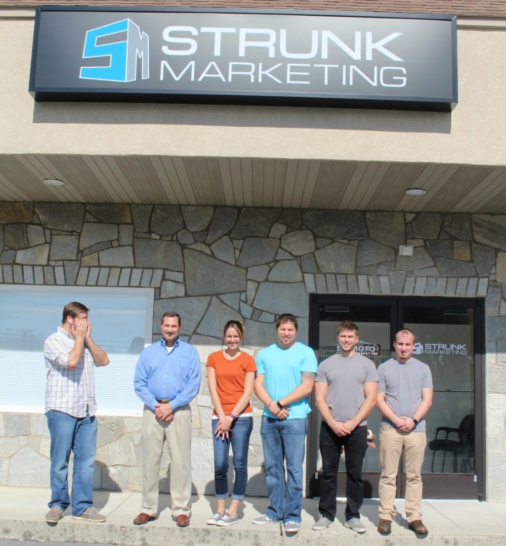 A group of employees standing outside of Stunk Media Group.