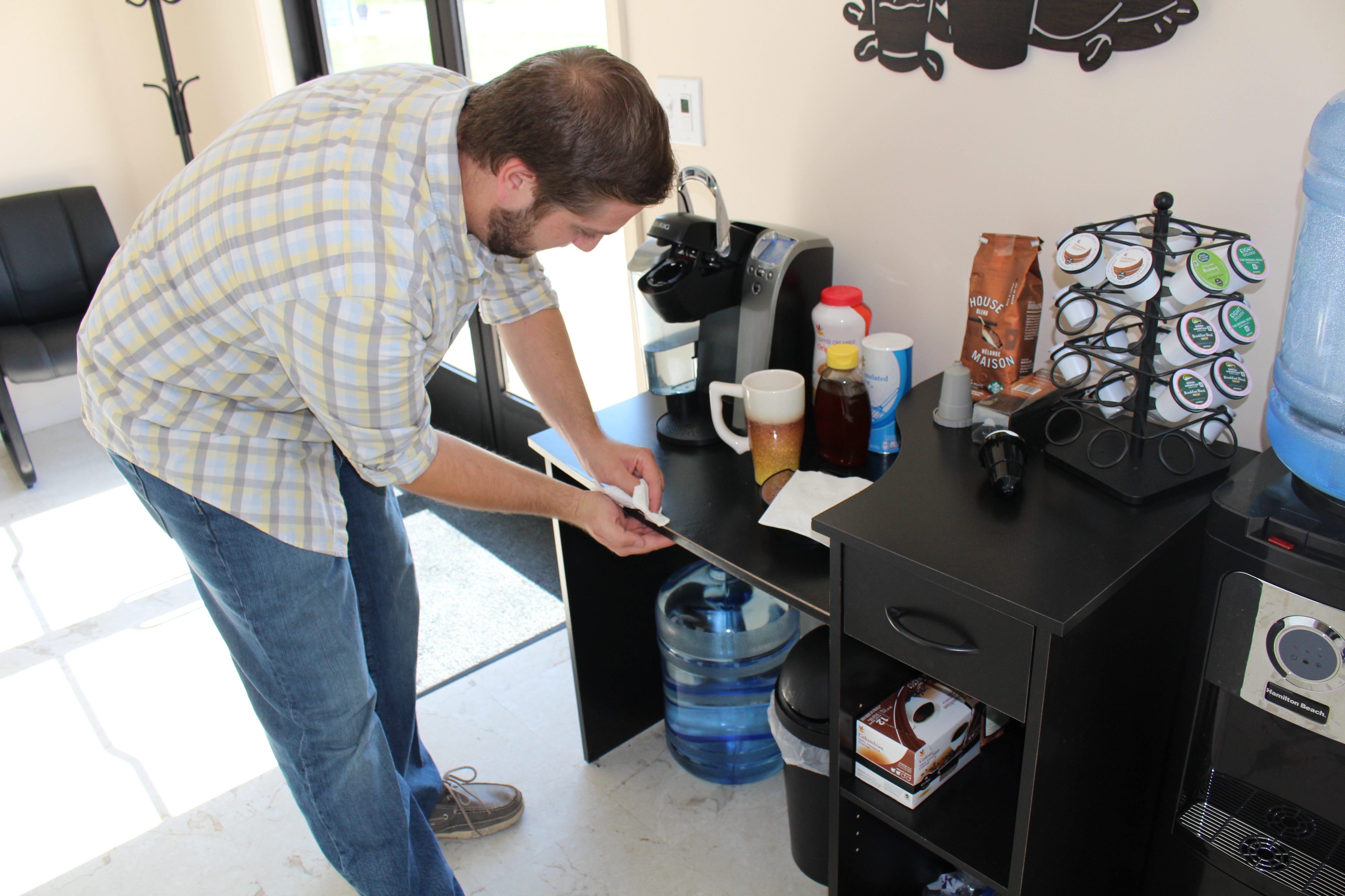A picture of a man at a coffee maker.