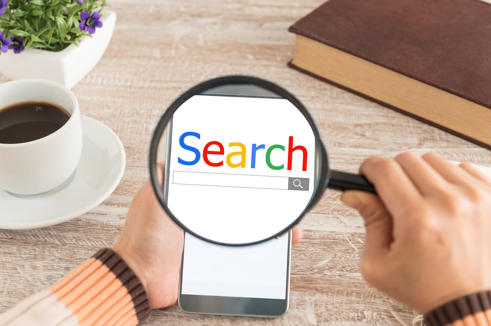 search engine concept image with phone and magnifying glass